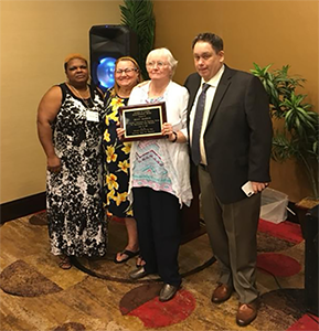 Eddie Turner, Rose Lucious, and Juanita Bishop presenting Peggy Maddox with the George W. Cantin Humanitarian Award.